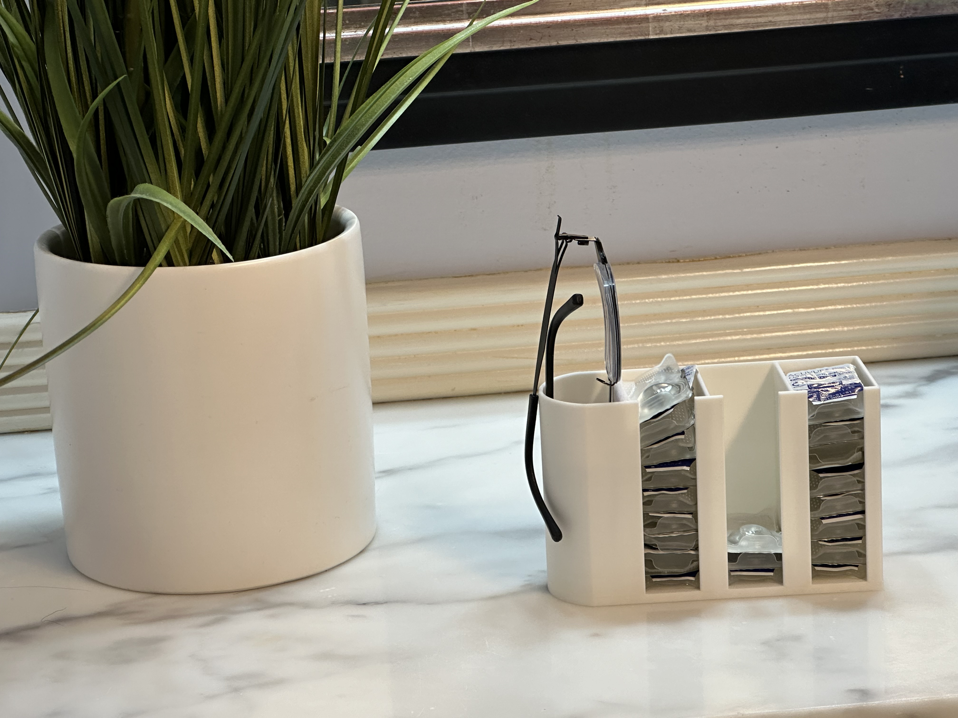 Glasses and contact lens holder on countertop